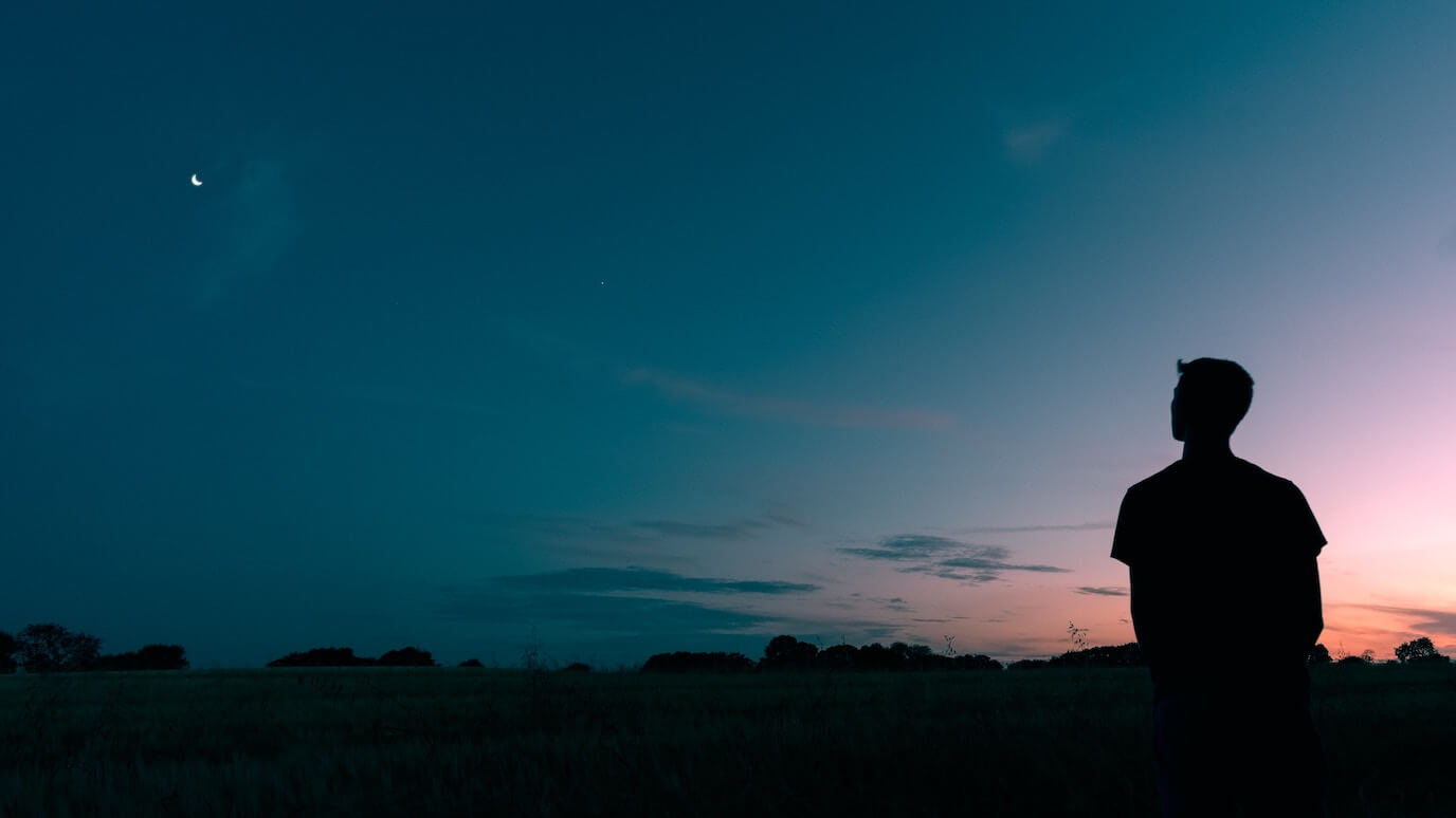 photo of a man by himself looking at a star