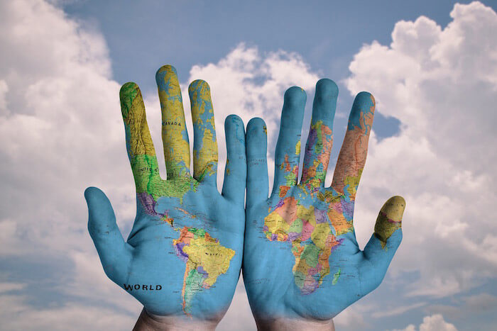 Hands with world map painted on them